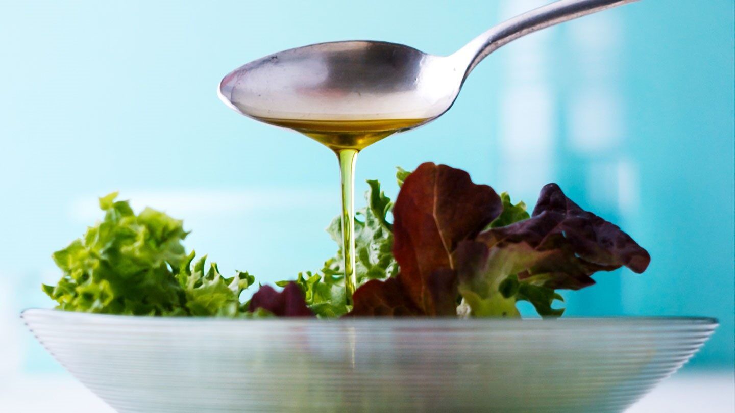 olive oil being put on a salad