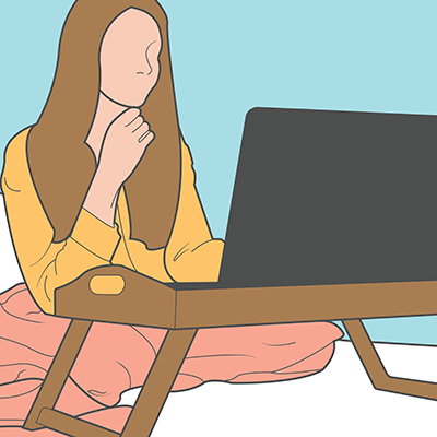 Person sitting comfortably with a blanket and a laptop.