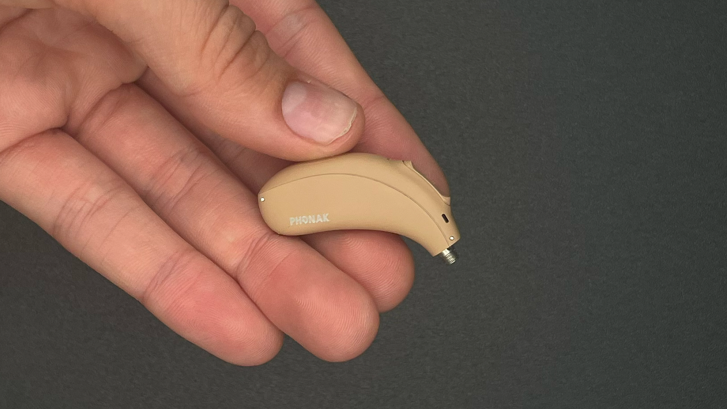 Our reviewer holding a Phonak Naída Paradise P-UP hearing aid